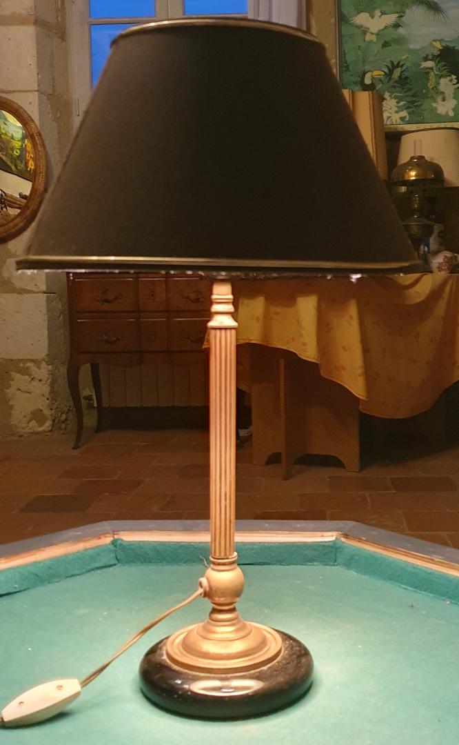 Lampe de style empire, base ronde noire en verre diamètre 14 cm, surmontée d'une base en métal doré avec un fût cannelé d'une hauteur de 26 cm. L'abat jour noire est fini par un liserait doré en haut et en bas. L'interieur de l'abat jour est doré.Le mécanisme interupteur marche correctement. Hauteur total : 49 cm. Prix : 125,00 €uros