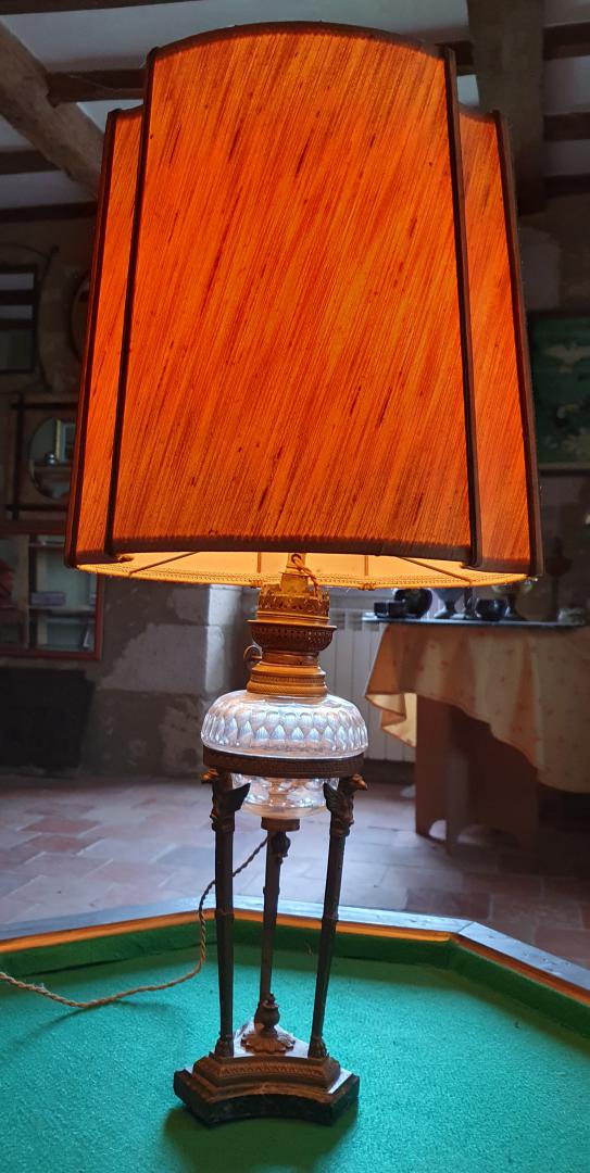 Lampe de style empire, base en marbre, surmontée d'une stucture en métal doré.A la base de la douille se trouve une corolle en verre L'abat jour en forme aérienne est souligné par un liserait noir. Hauteur total : 74 cm. Prix : 175,00 €uros